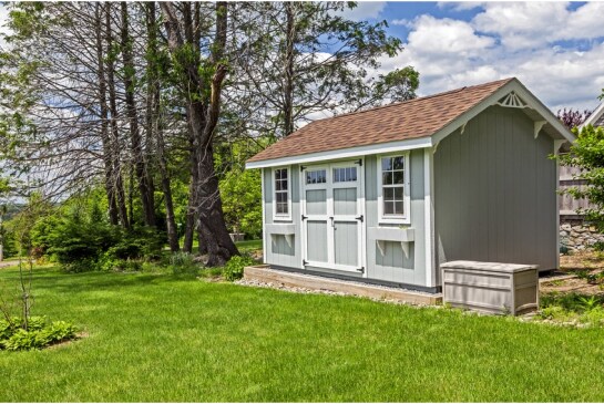 Light gray shed with brown GAF shingle roof